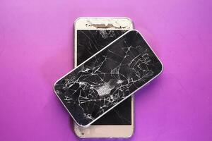 Close up of broken smart phone on color background photo