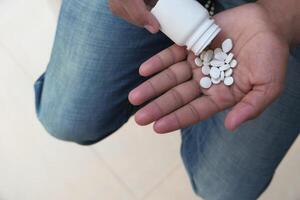 high angle view of pills and container on hand photo