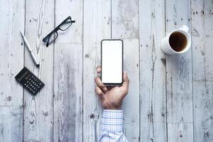 man holding smartphone with empty screen, high angle view photo