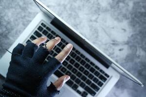 Close up of hacker hand stealing data from laptop photo