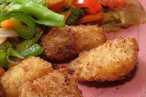 Fried chicken nuggets and salad on plate . photo