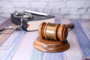 Close up of gavel, book and handcuff on table photo