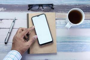 man holding smartphone with empty screen, high angle view photo