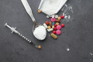 high angle view of heroine, spoon and syringe on table photo