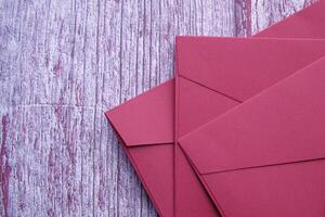 high angle view of red color envelope wooden background photo