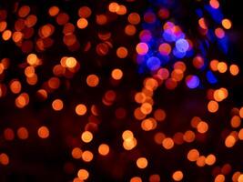 The image is a blurry, colorful background of orange and blue lights photo