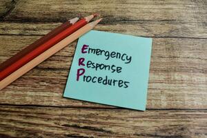 Concept of ERP - Emergency Response Procedures write on sticky notes isolated on Wooden Table. photo