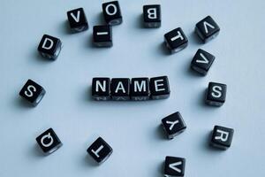 Concept of Name written on wooden blocks. Cross processed image on Wooden Background photo