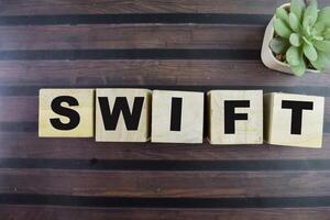 Concept of The wooden Cubes with the word Swift on wooden background. photo