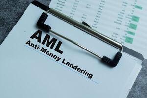 Concept of AML - Anti-Money Landering write on paperwork isolated on wooden background. photo