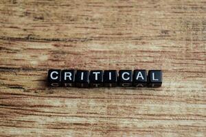 Concept of Critical written on wooden blocks. Cross processed image on Wooden Background photo