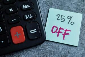 Concept of 25 percent Off write on sticky notes isolated on Wooden Table. photo