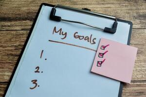 Concept of My Goals write on paperwork with Supported by an additional services isolated on wooden background. photo