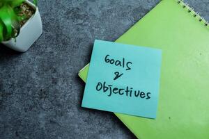 Concept of Goals and Objectives write on sticky notes isolated on Wooden Table. photo