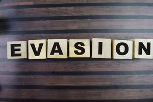 Concept of The wooden Cubes with the word Evasion on wooden background. photo