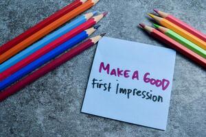 Concept of Make A Good First Impression write on sticky notes isolated on Wooden Table. photo
