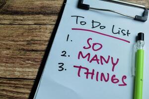 Concept of To do List - So Many Things write on paperwork isolated on wooden background. photo