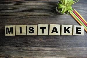 Concept of The wooden Cubes with the word Mistake on wooden background. photo