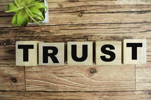 Concept of The wooden Cubes with the word Trust on wooden background. photo