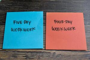 Concept of Five-day Workweek or Four-day Workweek write on sticky notes isolated on Wooden Table. photo