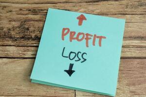 Concept of Profit or Loss write on sticky notes isolated on Wooden Table. photo