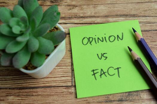 Concept of Opinion vs Fact write on sticky notes isolated on Wooden Table. photo
