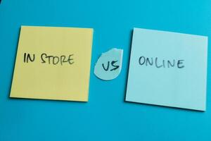 Concept of In Store vs Online write on sticky notes isolated on Wooden Table. photo