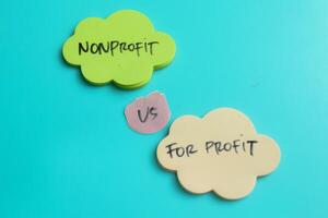 Concept of Nonprofit vs For Profit write on sticky notes isolated on Wooden Table. photo
