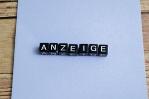 Concept of The wooden Cubes with the word Anzeige it means Advertisement on wooden background. German language isolated on Wooden Table. photo