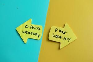 Concept of 6 Hour workday or 8 hour workday write on sticky notes isolated on Wooden Table. photo