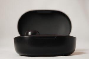 Black Wireless Earbuds Resting in Case photo
