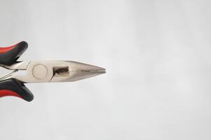 A pair of pliers with a small hole in the middle of the handle photo