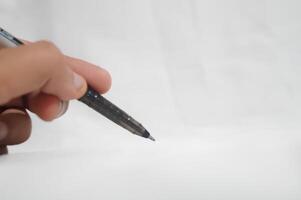 A person is writing with a pen on a white background photo