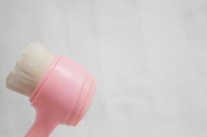 A pink brush is shown with its bristles facing up photo