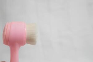 A pink and white brush is shown on a white background photo