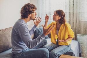 Man and woman are sitting at sofa and arguing. Relationship problems. photo