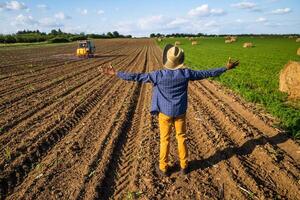 African farmer is standing in his agricultural field. He is supervising the spraying of the field. photo