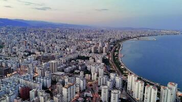 A mesmerizing drone capture of Mersin, Turkey, at sunset. The vibrant cityscape extends along the coastline, with the warm glow of the setting sun casting a magical light over the scene video