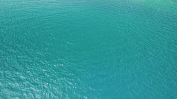 Structure of blue ocean water, seen from above by a drone. Tropical scenery. Lagoon's blue surface. Vast ocean backdrop with gentle waves viewed directly from overhead video