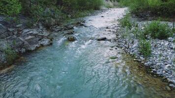 Drone captures low aerial view of clear, creek in rocky terrain. Clear, creek flows smoothly in secluded mountain area. Footage highlights adventurous spot with clear, creek video