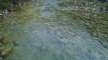 Drone of mountain stream, low angle view highlights clear water. Low angle view captures rocky terrain and secluded area. Footage showcases natural beauty in low angle view video