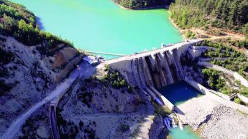Sustainable environment, dam and lake in valley drone view. Sustainable environment shown in emerald lake aerial. Sustainable environment with dam, forest mountain valley video