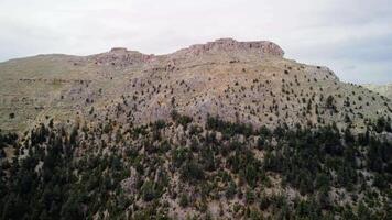 Drone footage of towering, mountain covered in dense forests. Aerial view shows towering, mountain reaching skyward in majestic display. captures towering, mountain surrounded by lush greenery video