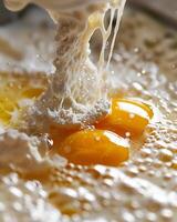 A close-up of a dough hook in action, egg yolks and whites swirling with yeast in the bowl of a mixer, the beginning of a delicious creation photo