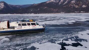 A hovercraft glides over a frozen mountain lake, symbolizing adventure and wilderness exploration video