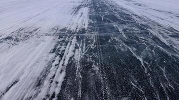 An Aerial View of a Frozen Ice Road Surface with Snow Patterns on a Clear Winter Day video