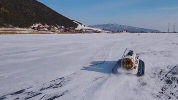 A Hovercraft smoothly glides across a Frozen Lake, with a Majestic Mountain in the Background video