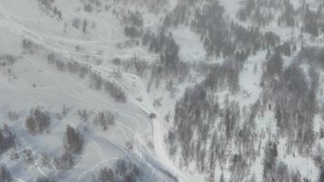 Aerial view captures a scenic snowy mountain landscape adorned with trees and snow trails video