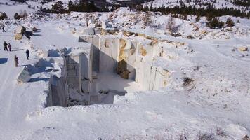 Snowy marble quarry seen from above, rocks sculpted by cutting, contrasting with winter environment video