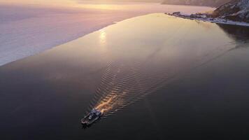 Tranquil boat peacefully floating on serene water as the sun sets in the background video